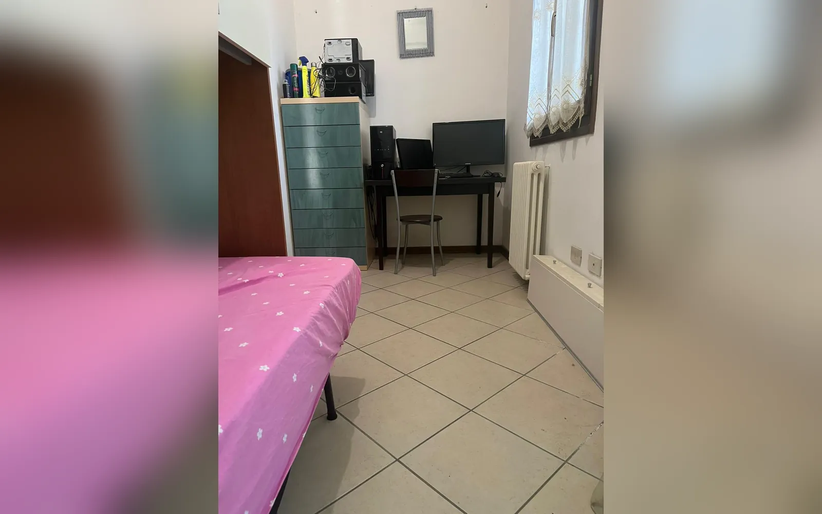 La camera singola con il letto, la scrivania e la cassettiera verde